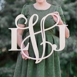 An image of a woman holding a mixed style wooden monogram sign from 48 Hour Monogram.