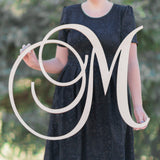 Woman holding one letter monogram sign