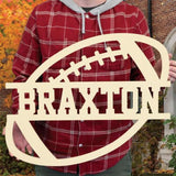 An image of a man holding a football wooden monogram sign from 48 Hour Monogram.