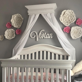 white wooden monogram sign above crib
